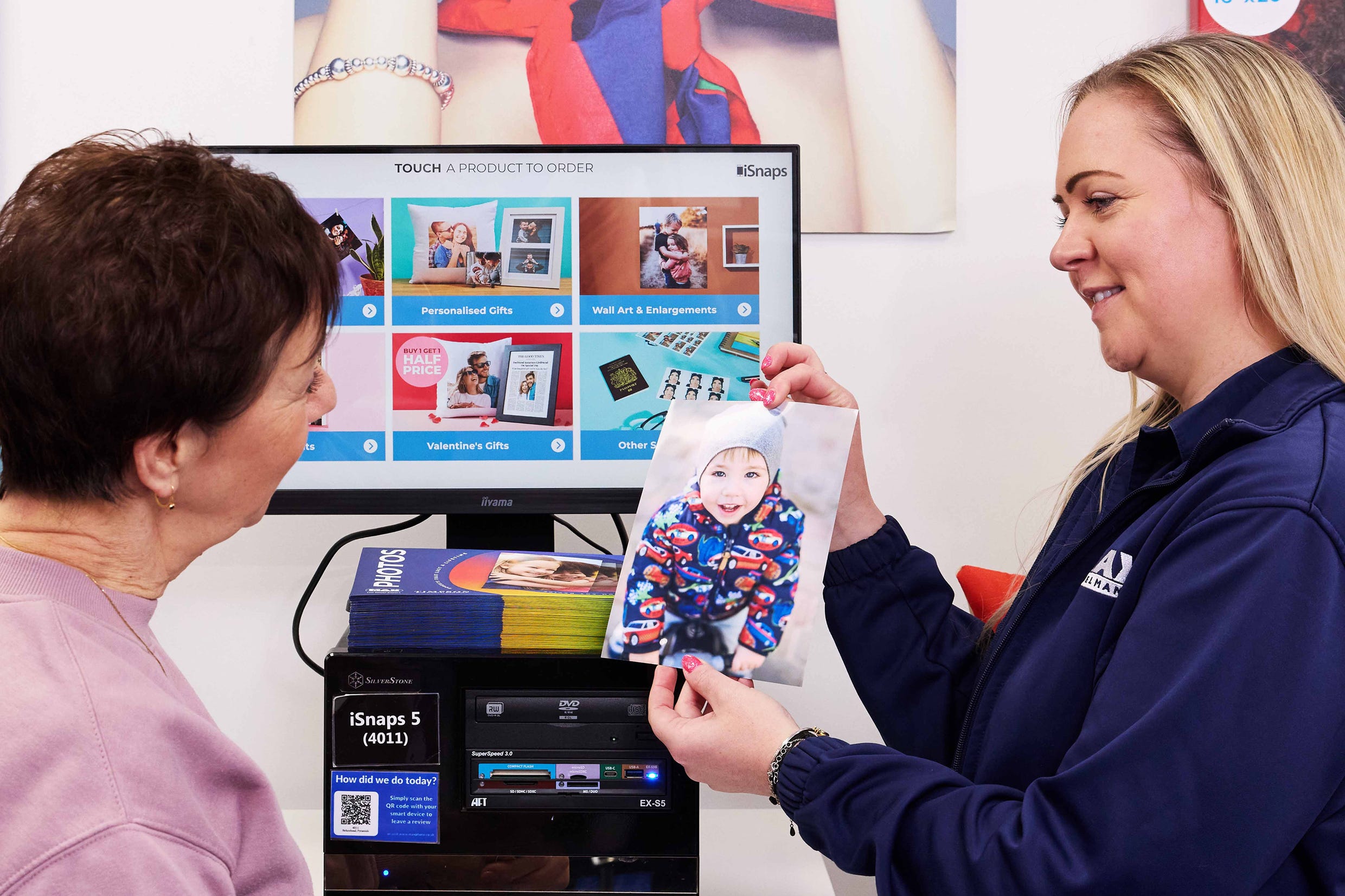 Max Spielmann employee assisting a customer with in-store photo printing.