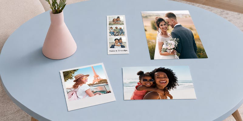 Different types of photo prints laid out on a round blue table.