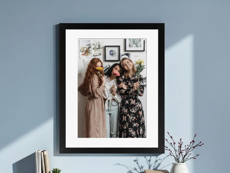 framed photo print of three female friends on a blue wall