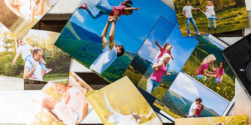 Father's Day photo prints spread out on a table. Images of Dad and kids/family